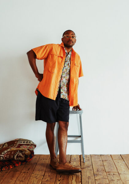 image of a man wearing an orange shirt and black shorts