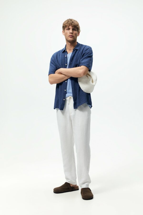 image of a man wearing white pants and blue shirt