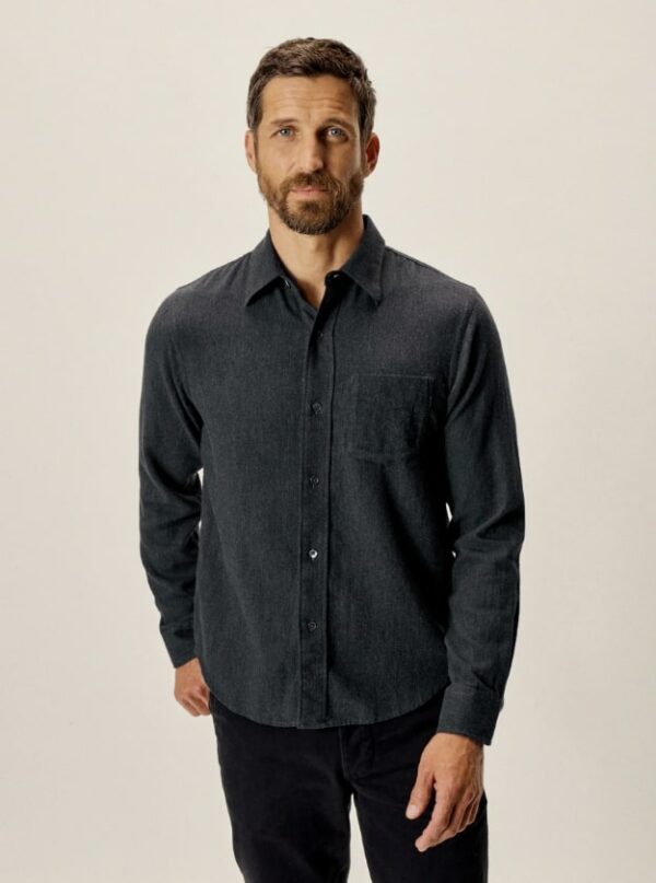 a man wearing a dark blue long sleeve button front shirt