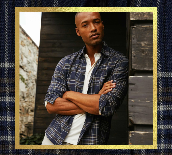 a man wearing a blue plaid shirt over a white shirt