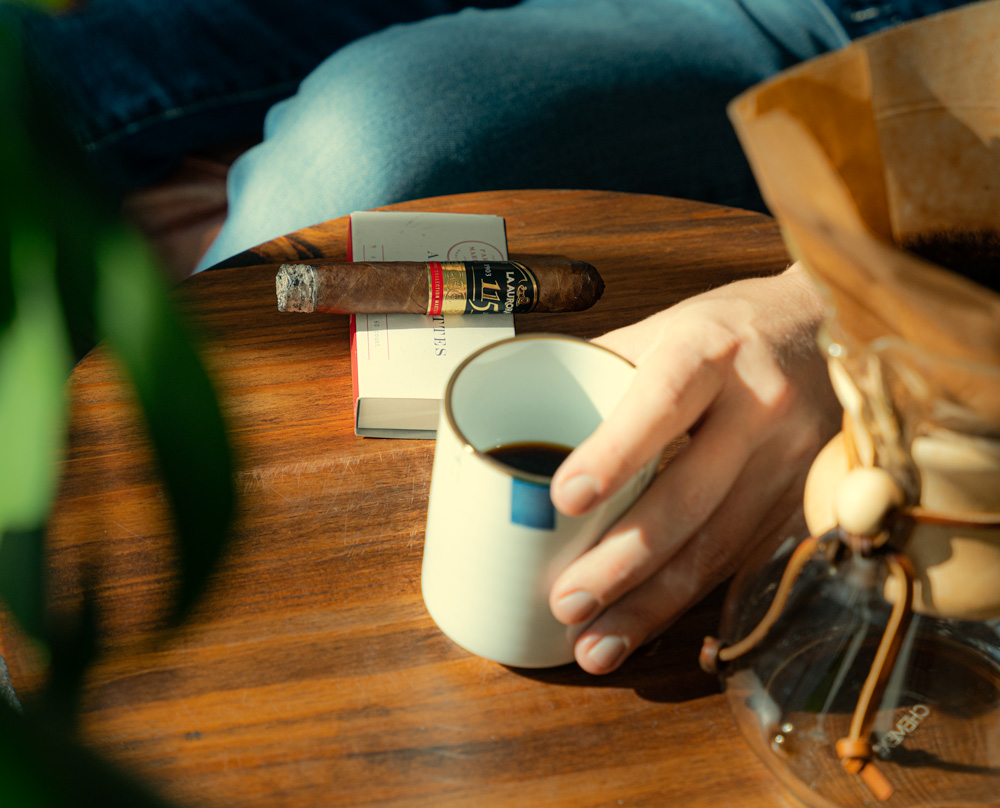 A cup of coffee next to a cigar