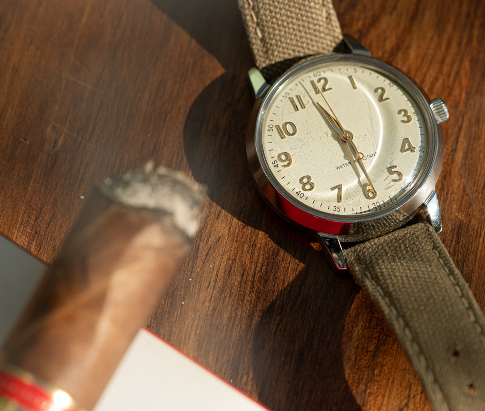 smoking cigar next to a watch
