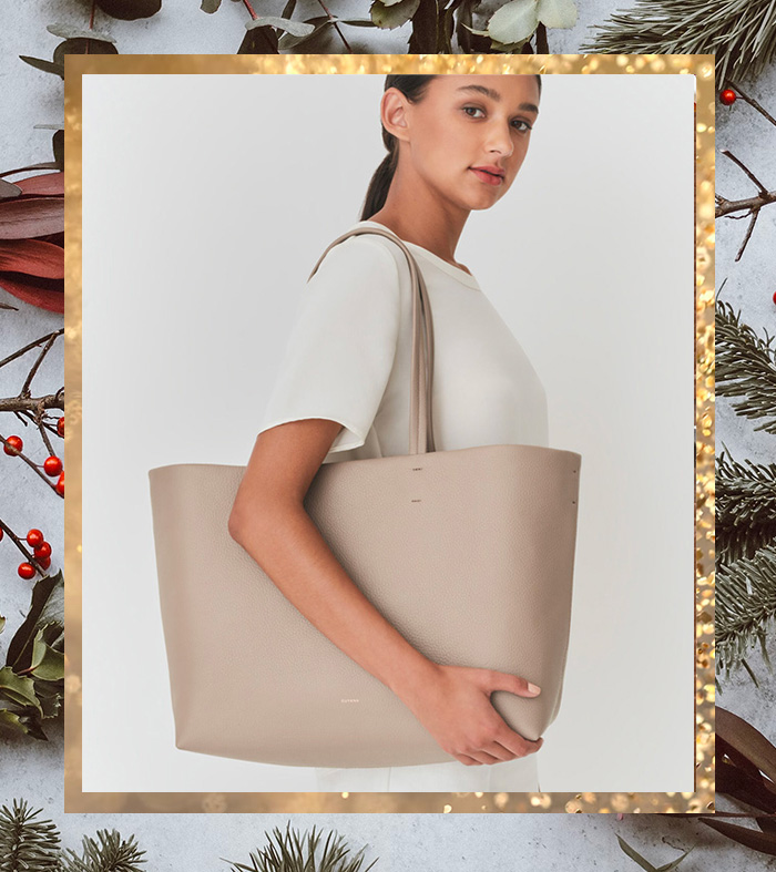 a woman carrying a large leather tote bag