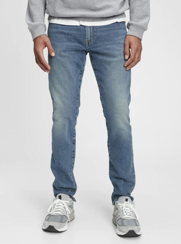 a person wearing blue denim jeans and white sneakers