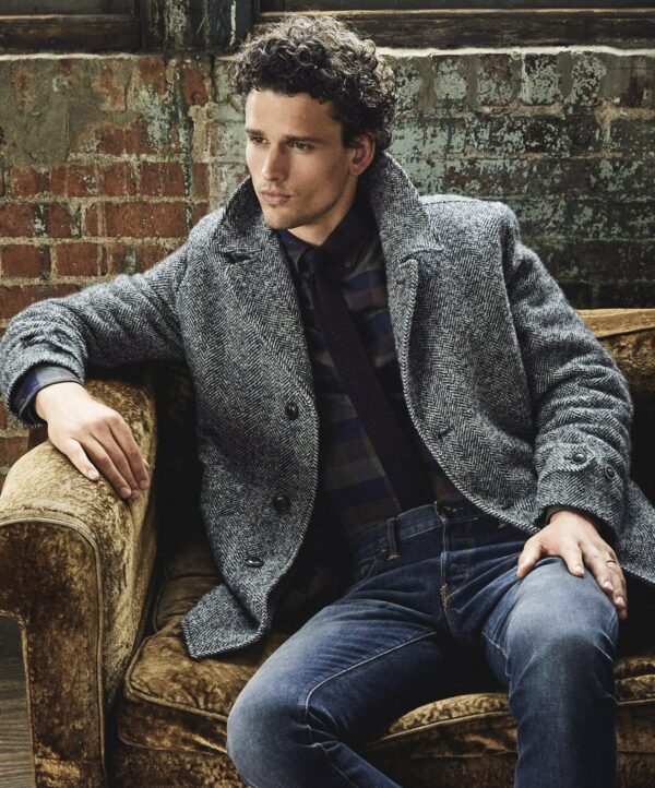 a man wearing a herringbone pattern car coat