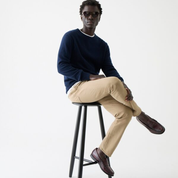 a man wearing slim fit khaki pants and a sweater