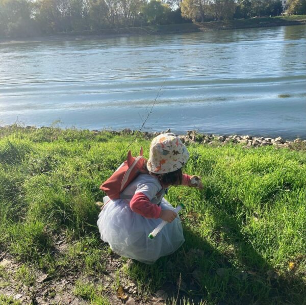 a child playing outdoors by a lake