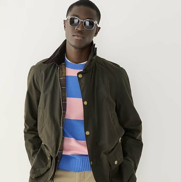 a man wearing a waxed cotton jacket over a striped shirt