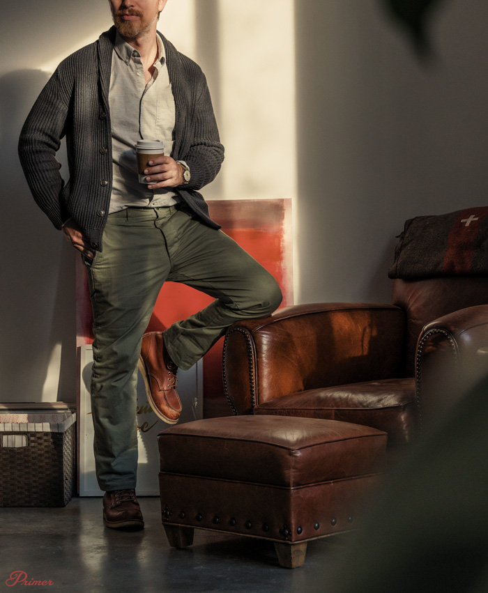 man wearing officer chinos with shawl collar sweater, button up shirt, and red wing boots