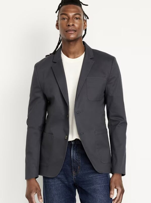 a man wearing a twill navy blazer over a crew neck shirt