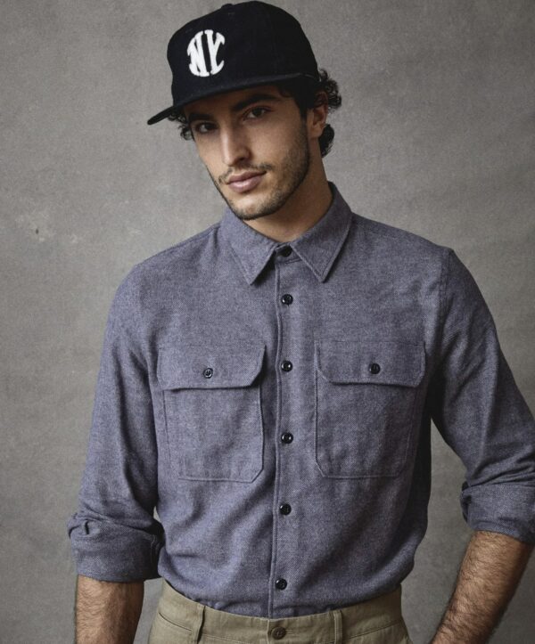 man wearing a chamois shirt and a logo hat