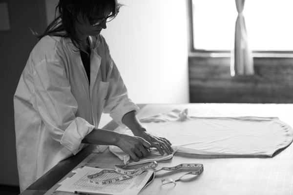 woman measuring a tshirt at buck mason mills