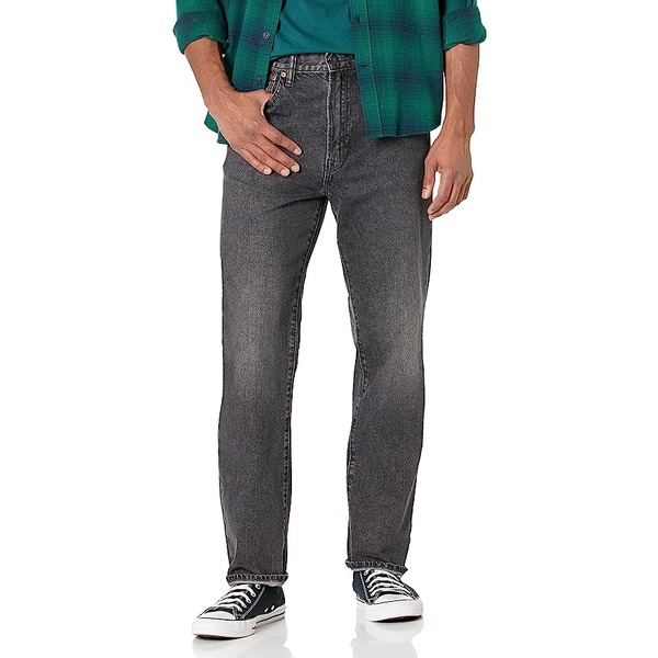 a man wearing straight fit denim jeans and low top sneakers