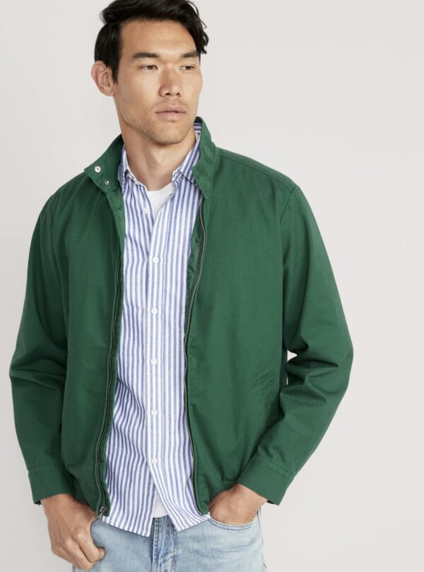 a man wearing a bomber style jacket over a button front collared shirt