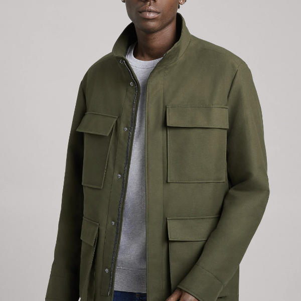 a man wearing a field jacket over a crew neck shirt