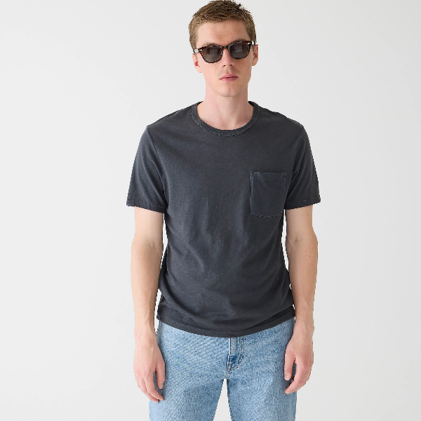 a man wearing a crewneck shirt with jeans and sunglasses