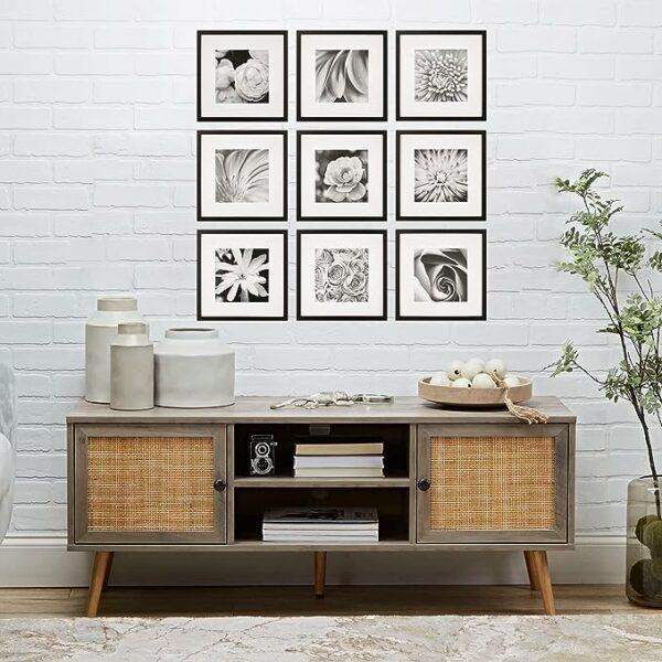 a set of nine photo gallery frames on a wall above a storage drawer