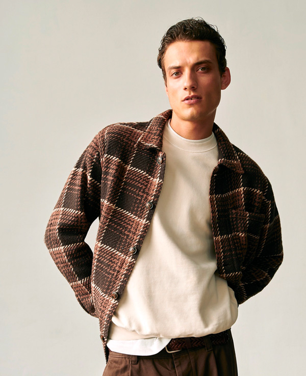 man wearing a madewell brown tone plaid shirt jacket over a sweatshirt
