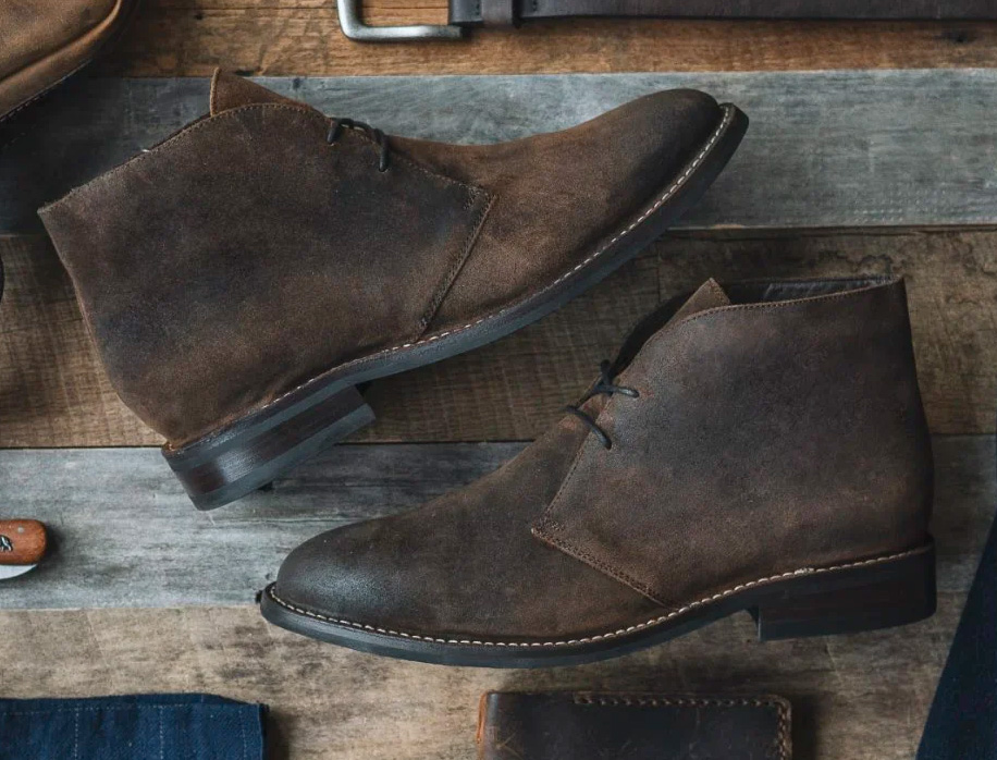 brown suede chukka boots on a wood floor