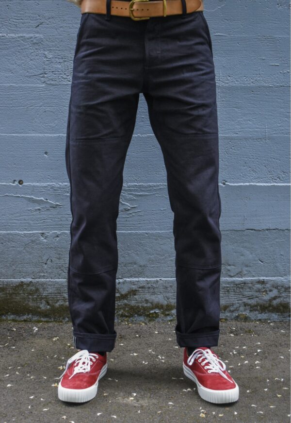 a man wearing work trousers and low top sneakers