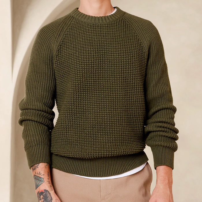man wearing an olive waffle knit sweater with raglan sleeves
