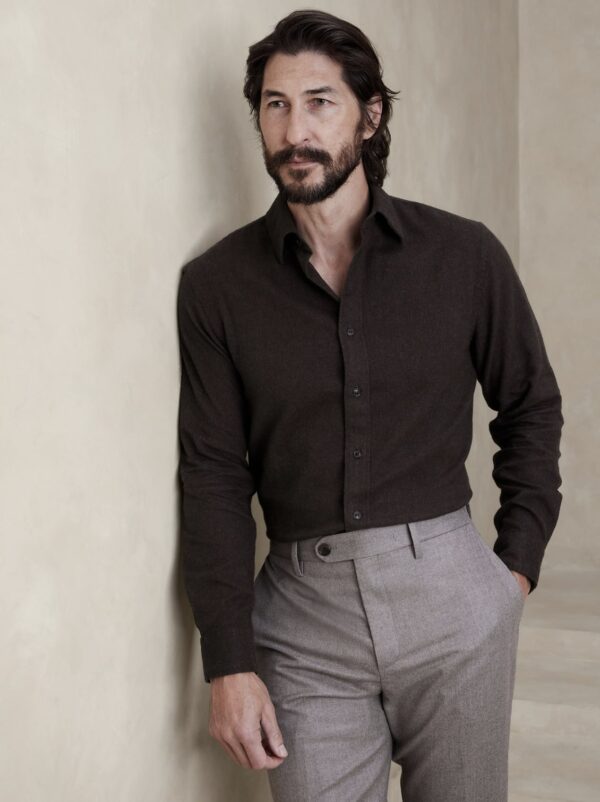 a man wearing a flannel shirt and trousers