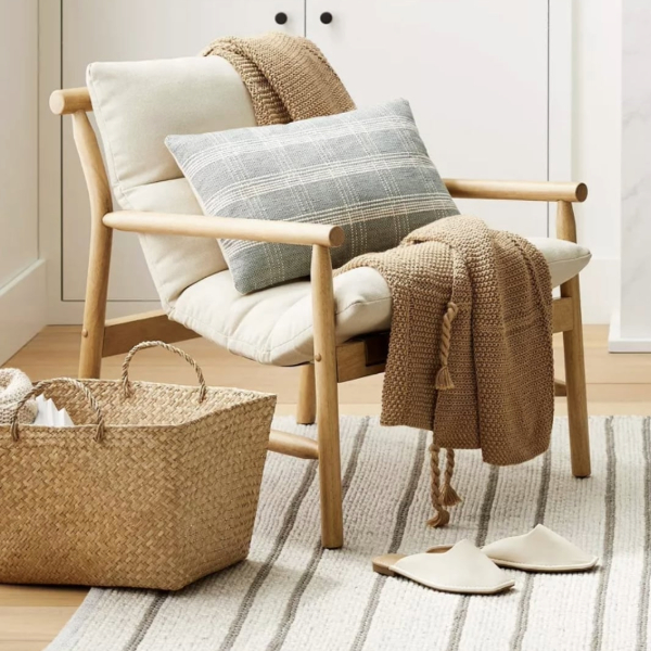 a small accent chair with a pillow and blanket
