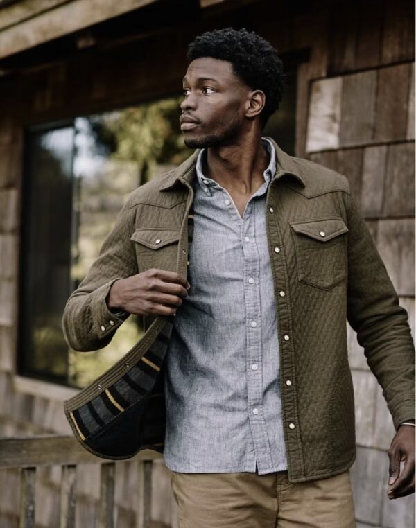 a man wearing a quilted western style shirt over a button up shirt