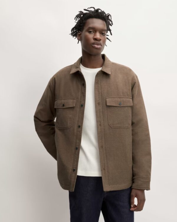 a man wearing a flannel filled shirt jacket over a shirt and denim jeans