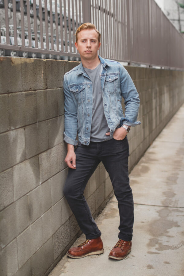 a man wearing a light wash denim jean jacket with a casual shirt slim fit pants and boots