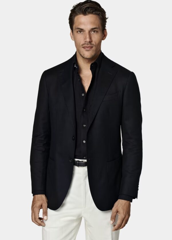 a man wearing a navy blazer over a button front dress shirt and dress pants