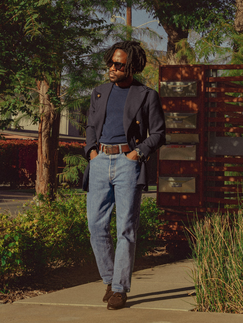 daniel wearing light wash jeans with a navy blazer, blue sweater, and loafers