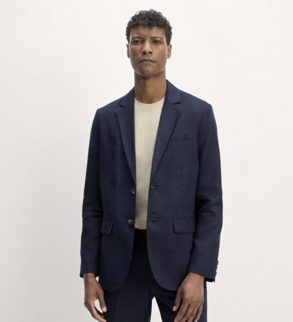 a man wearing a navy blazer over a casual crew neck shirt