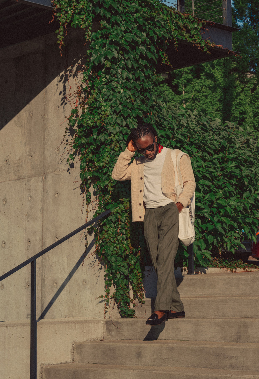 Daniel walking down stairs - mens summer outfit with linen pants, white tshirt, and cream cardigan