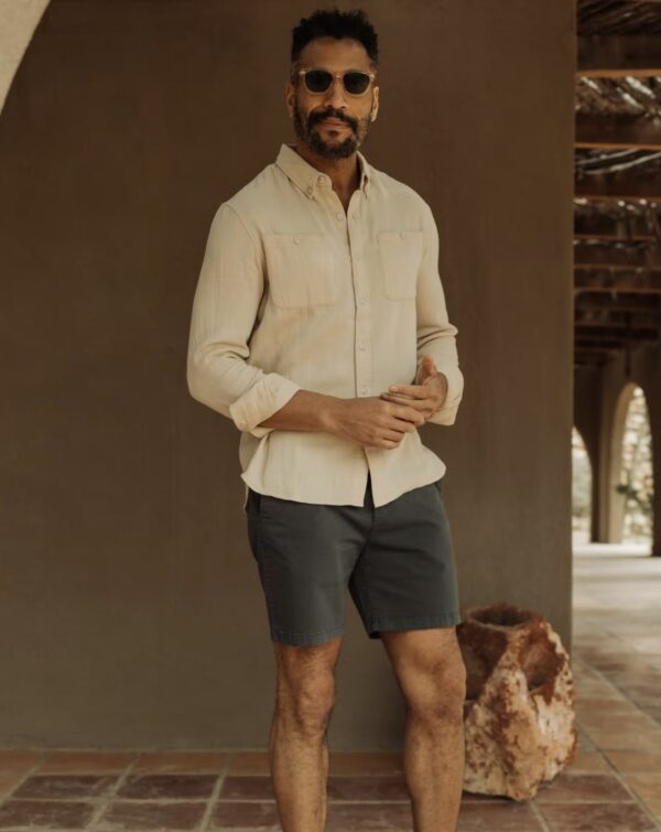 a man wearing shorts with a button up dress shirt and sunglasses