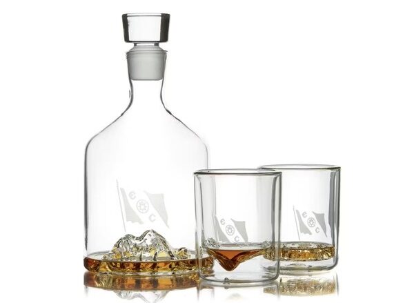 a glass decanter and set of two whiskey glasses with tophographic images of mount everest and tycho crater and marianas trench