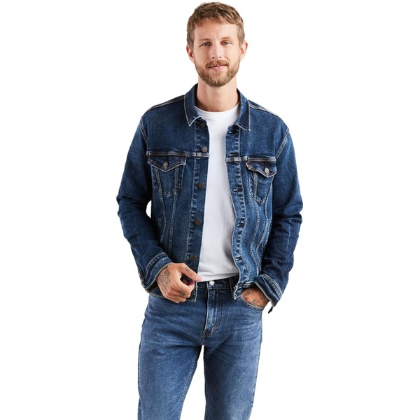 a man wearing a denim trucker jacket with denim jeans and a white shirt