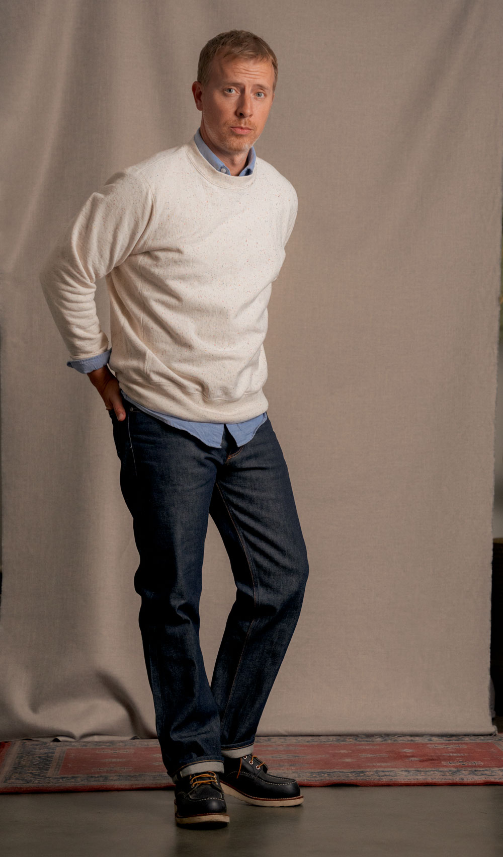 Andrew wearing a fall outfit comprise of the Gustin 1968 selvedge denim with the rainbow nep heavyweight sweatshirt with a blue oxford underneath