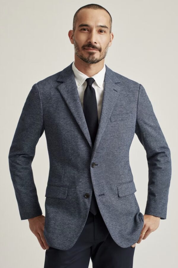 a man wearing a knit stretch blazer with a shirt and tie