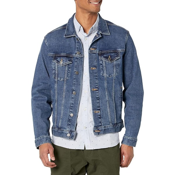 a man wearing a denim jacket over a button front shirt and pants