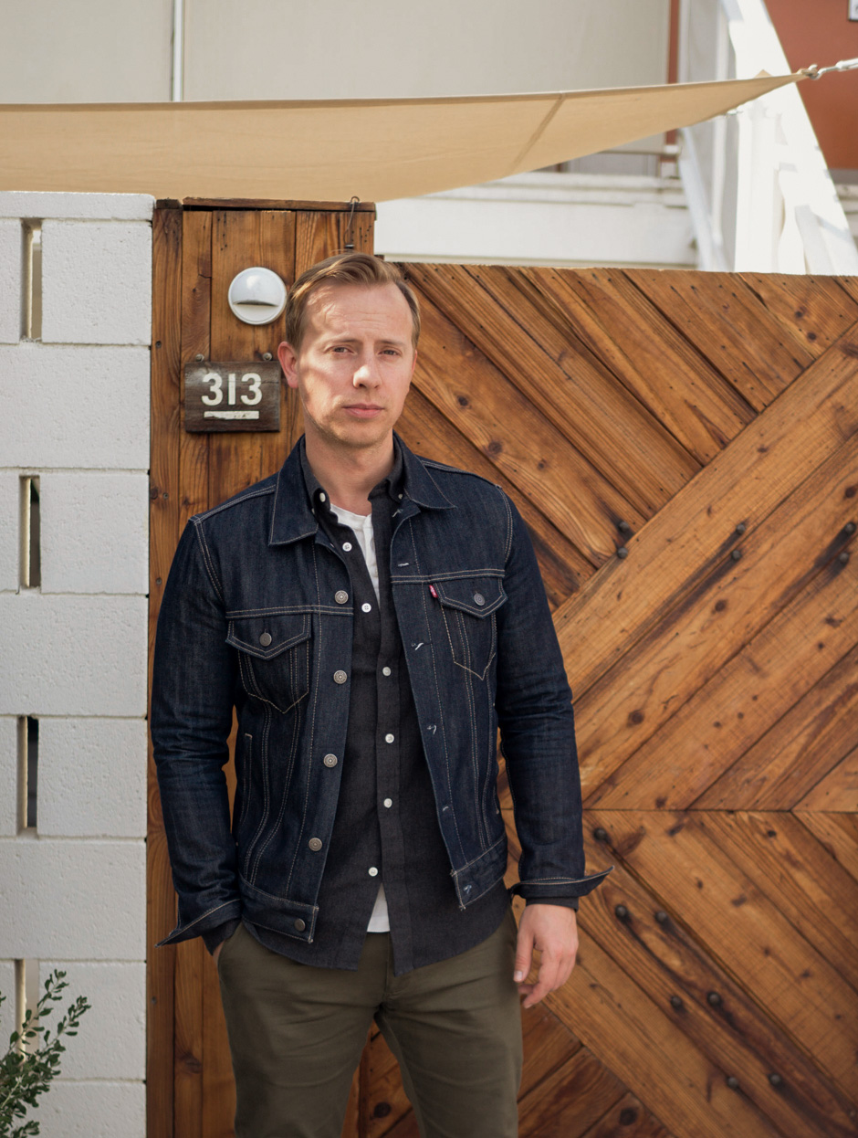 a men's casual outfit with a jean jacket, dark gray flannel shirt, white henley with olive chinos