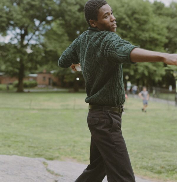 man wearing a cable knit rollneck sweater and casual pants