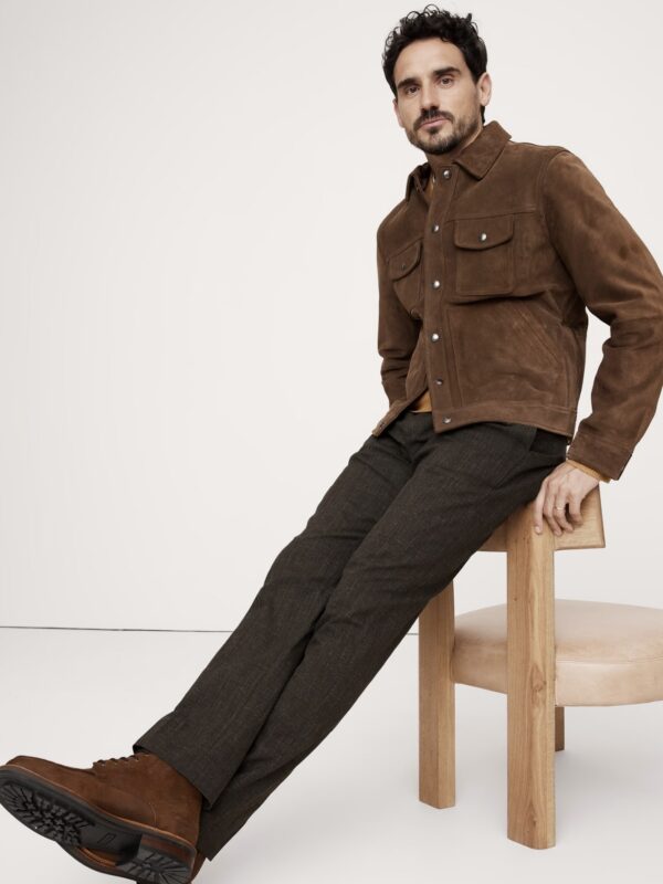 man wearing wrinkle resistant dress pants with a trucker jacket and boots