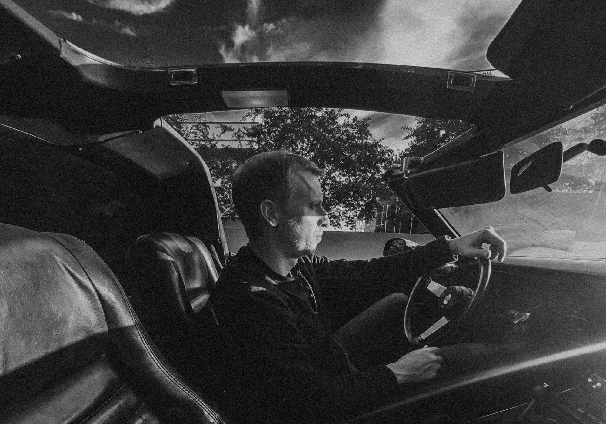 black and white photo of andrew driving car