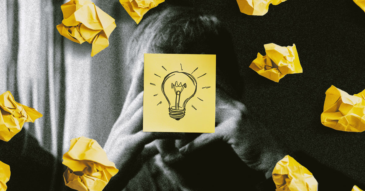 image a man with his head in his hands and several crumpled pieces of paper surrounding him and a center image of a drawing of a lightbulb