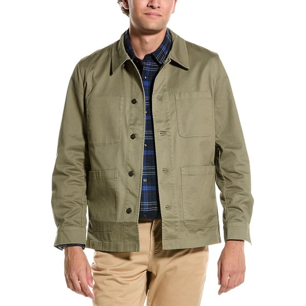 a man wearing a twill chore style coat over a casual shirt and chino pants