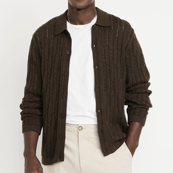 a man wearing a cable knit cardigan over a crew neck shirt and pants