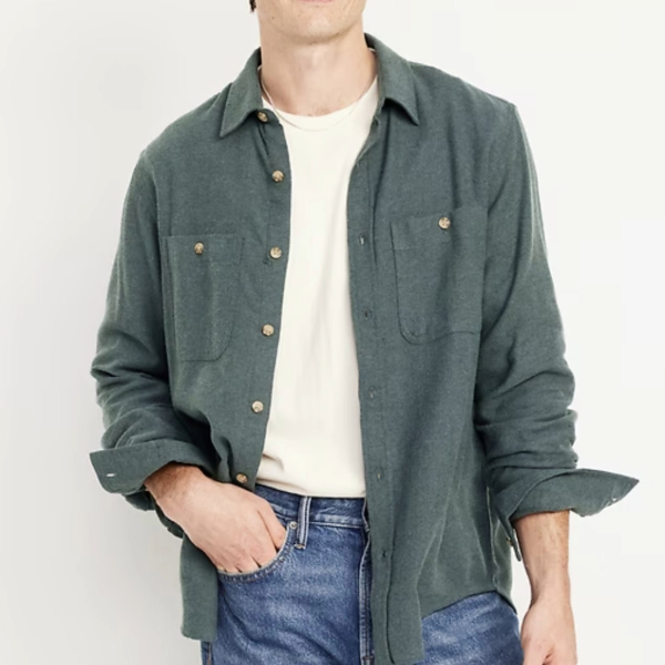 a man wearing a flannel shirt over a crew neck shirt and jeans