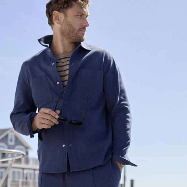 a man wearing a button front knit shirt jacket over a striped shirt