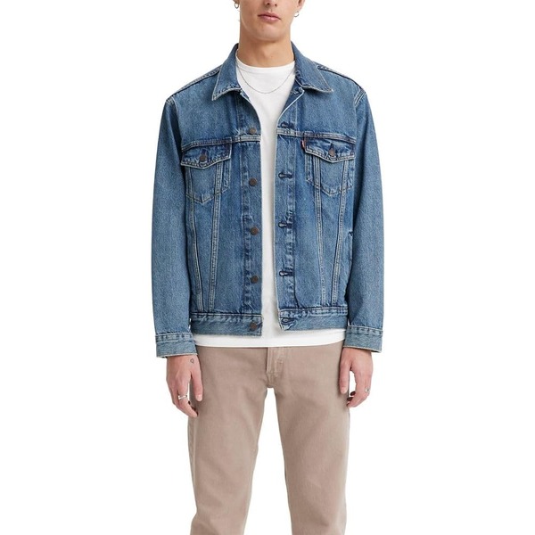 a man wearing a relaxed fit trucker jacket over a shirt and pants